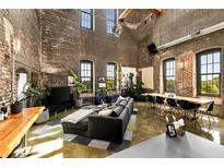 Expansive living room features exposed brick walls, large windows, and modern decor at 170 Boulevard Se # H523, Atlanta, GA 30312
