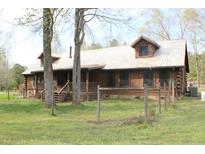 Charming log home with a metal roof, inviting front porch, and a well-maintained yard at 512 E Valley Ne Rd, Rydal, GA 30171