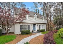 Charming two-story home featuring a brick walkway, manicured landscaping, and a light gray painted exterior at 2385 Hanover West Ln, Atlanta, GA 30327