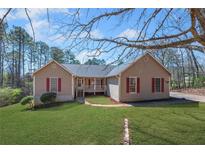 Charming ranch-style home with a well-manicured lawn, inviting curb appeal, and a cozy front porch at 100 Cowan Trl, Stockbridge, GA 30281