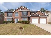 Charming two-story brick home with a two-car garage and well-maintained landscaping at 7178 Cavender Sw Dr, Atlanta, GA 30331