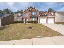 Beautiful two-story brick home featuring a two-car garage and well-manicured lawn at 7178 Cavender Sw Dr, Atlanta, GA 30331