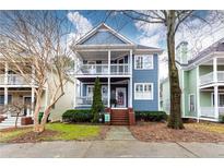 Charming two-story home with blue siding, inviting front porch, and well-maintained landscaping at 1064 Lena Nw St, Atlanta, GA 30314