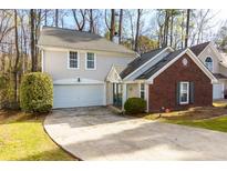 Two-story home featuring a brick facade, two-car garage, and well-manicured landscaping at 633 N Fairfield Dr, Peachtree City, GA 30269