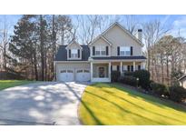 Charming two-story home boasts a manicured lawn, a two-car garage and inviting front porch at 313 Sable Trace Pass, Acworth, GA 30102