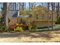 View of house with wood deck, tan siding, natural landscaping, and mature trees surrounding the home at 3405 Woodrun Ne Trl, Marietta, GA 30062