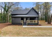 Charming craftsman home featuring a stylish dark exterior, inviting porch, and landscaped front yard at 4538 Arcado Sw Rd, Lilburn, GA 30047