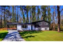 Charming home featuring a convenient carport, two-tone paint, and well-maintained lawn at 1785 Hammond Woods Sw Cir, Marietta, GA 30008