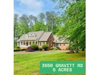 Charming brick home on five acres with manicured lawn and mature trees at 3550 Gravitt Rd, Cumming, GA 30040