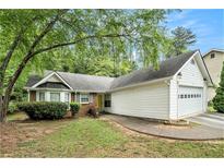 Charming single-story home with a well-manicured lawn, a brick facade, and an attached two-car garage at 5936 Old Wellborn Trce, Lithonia, GA 30058
