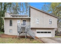 Charming home featuring a front porch with grey painted wood, and an attached two-car garage at 3807 Memorial Nw Pkwy, Kennesaw, GA 30152
