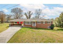 Charming brick home with a carport and landscaped front yard showcasing classic suburban appeal at 2852 Crabapple Lane, Dacula, GA 30019