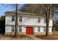 Charming two-story home with white siding, stone accent and a vibrant red double-door entrance at 1139 Pinedale Nw Cir, Conyers, GA 30012