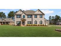 Stunning two-story home with a brick facade, lush lawn, and meticulously landscaped front yard at 701 Cupcake Ct, Mcdonough, GA 30252