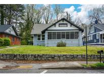 Charming bungalow home featuring a screened front porch and stone retaining wall at 984 Cascade Sw Rd, Atlanta, GA 30311
