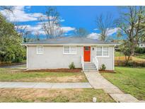 Charming single-story home with a freshly painted exterior, red door, and well-maintained front yard at 869 Capitol View Nw Ave, Atlanta, GA 30318