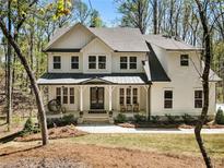 Charming two-story home with white siding, covered front porch, and well-manicured landscaping at 3560 Chattahoochee Rd, Cumming, GA 30041