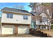 Two-story home featuring a brick facade, two-car garage, and a charming front entrance at 2099 Winsburg Nw Way, Kennesaw, GA 30144