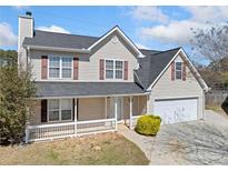 Charming two-story home with a manicured lawn, two-car garage, and inviting front porch at 3313 Summit Creek Ln, Loganville, GA 30052