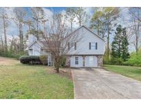 Charming two-story home featuring light gray siding, stone accents, and a well-manicured front lawn at 6405 Grafton Dr, Austell, GA 30168
