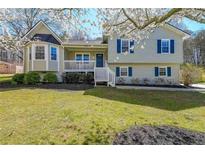 Charming split-level home with a well-manicured lawn, inviting porch, and blue shutters at 1692 Cumberland Trce, Acworth, GA 30102