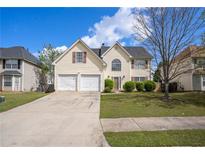 Charming two-story home with a two-car garage, a well-manicured lawn, and a classic suburban appeal at 1297 Partridge Ln, Riverdale, GA 30296