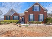Charming brick home with manicured landscaping, walkway lights and a well-maintained lawn on a sunny day at 748 Chanson Sw Dr, Marietta, GA 30064