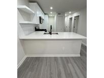 Bright kitchen with a quartz countertop island, stainless steel appliances and gray laminate flooring at 596 Windchase Ln, Stone Mountain, GA 30083