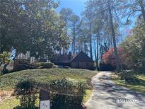 Charming single-Gathering home featuring mature landscaping, brick details, and a private driveway at 285 Old College Way, Atlanta, GA 30328