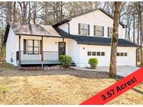 Charming two-story home featuring a covered porch, a two-car garage, and a well-manicured lawn at 6730 Alvan Ct, Riverdale, GA 30296