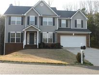 Charming two-story home with gray siding, black shutters, and a well-manicured lawn at 9025 Montclair Hills Dr, Cumming, GA 30028