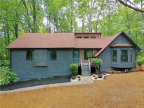 Charming home with teal door, lovely landscaping, and a wooded view at 4843 Caboose Nw Ln, Acworth, GA 30102