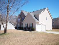 Charming two-story home featuring a two-car garage, brick accents, and well-maintained landscaping at 7267 Appaloosa Cv, Fairburn, GA 30213