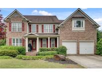Charming brick two-story home with red shutters, well-manicured landscaping, and a welcoming front porch at 179 Bradshaw Park Dr, Woodstock, GA 30188