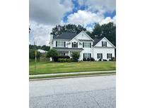 Charming two-story home features a well-maintained lawn and a classic black and white color scheme at 540 Langley Creek Dr, Loganville, GA 30052