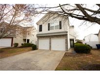 Two-story home featuring a two-car garage, neutral siding, a stone veneer and manicured landscaping at 102 Silver Fox Trl, Dallas, GA 30157