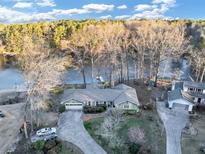 A captivating aerial view of a home nestled by the serene lake, surrounded by lush trees and inviting waters at 4258 Rocky Ledge Way, Snellville, GA 30039