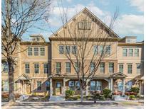 Attractive townhome featuring a symmetrical facade, covered porch, and manicured landscaping at 507 Grove Field Ct, Suwanee, GA 30024