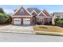 Charming brick home with a two-car garage and well-maintained landscaping at 1993 Shenley Park Ln, Duluth, GA 30097