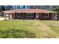 Charming brick home featuring a well-manicured lawn and a convenient carport at 4715 Greensprings Rd, College Park, GA 30337