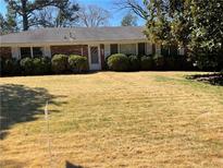 Traditional brick home featuring a well-manicured lawn and mature landscaping in a desirable neighborhood at 475 Maxwell Rd, Roswell, GA 30075