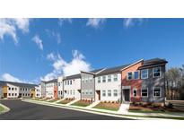 View of new construction townhomes with colorful facades and modern architectural details under a blue sky at 1590 Driggs Nw Dr # 166, Atlanta, GA 30318