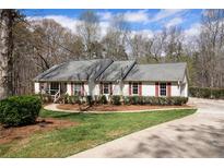 Charming single-story home boasts well-maintained landscaping, red shutters, and a cozy front porch at 4150 E East Chapel Hill Rd, Douglasville, GA 30135