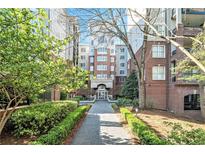 Elegant brick apartment building with a meticulously landscaped walkway leading to the entrance at 50 Biscayne Nw Dr # 5112, Atlanta, GA 30309
