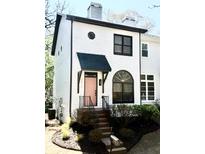 Charming two-story home with a light pink front door, neat landscaping and a stairway leading to the entrance at 2411 Charleston Oaks Ln, Decatur, GA 30030