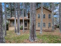 Two-story home featuring wood siding and surrounded by mature trees, creating a private, wooded setting at 444 Wellington Way, Jonesboro, GA 30238