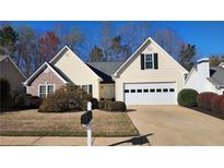 Charming single-Gathering home featuring a two-car garage, manicured lawn, and traditional architecture at 455 Ellesmere Way, Buford, GA 30518