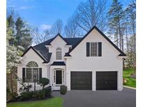 Charming two-story home featuring a manicured lawn, black shutters, and a two-car garage at 1288 Gate Post Ln, Powder Springs, GA 30127