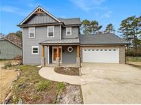 Charming two-story home featuring gray siding, a stone-accented porch, and an attached two-car garage at 1029 Gate Post Ln, Lawrenceville, GA 30044