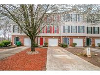 Charming townhomes with brick facades, colorful shutters, and attached garages for convenient parking at 3302 Waldrop Trl, Decatur, GA 30034